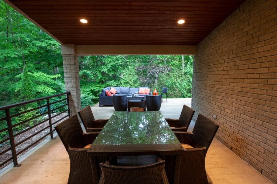 Covered patio looking out to large wooden deck